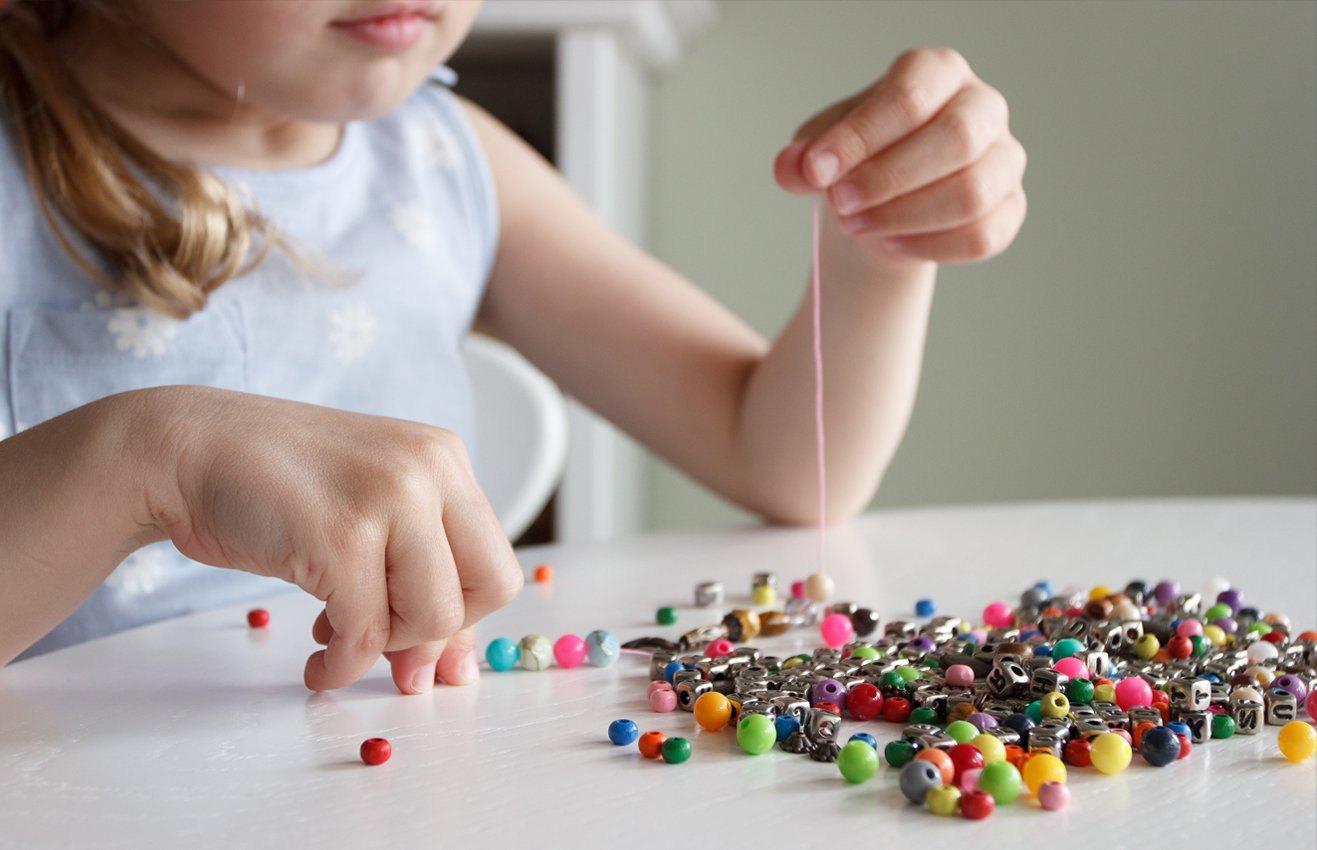 Girl playing with small beads