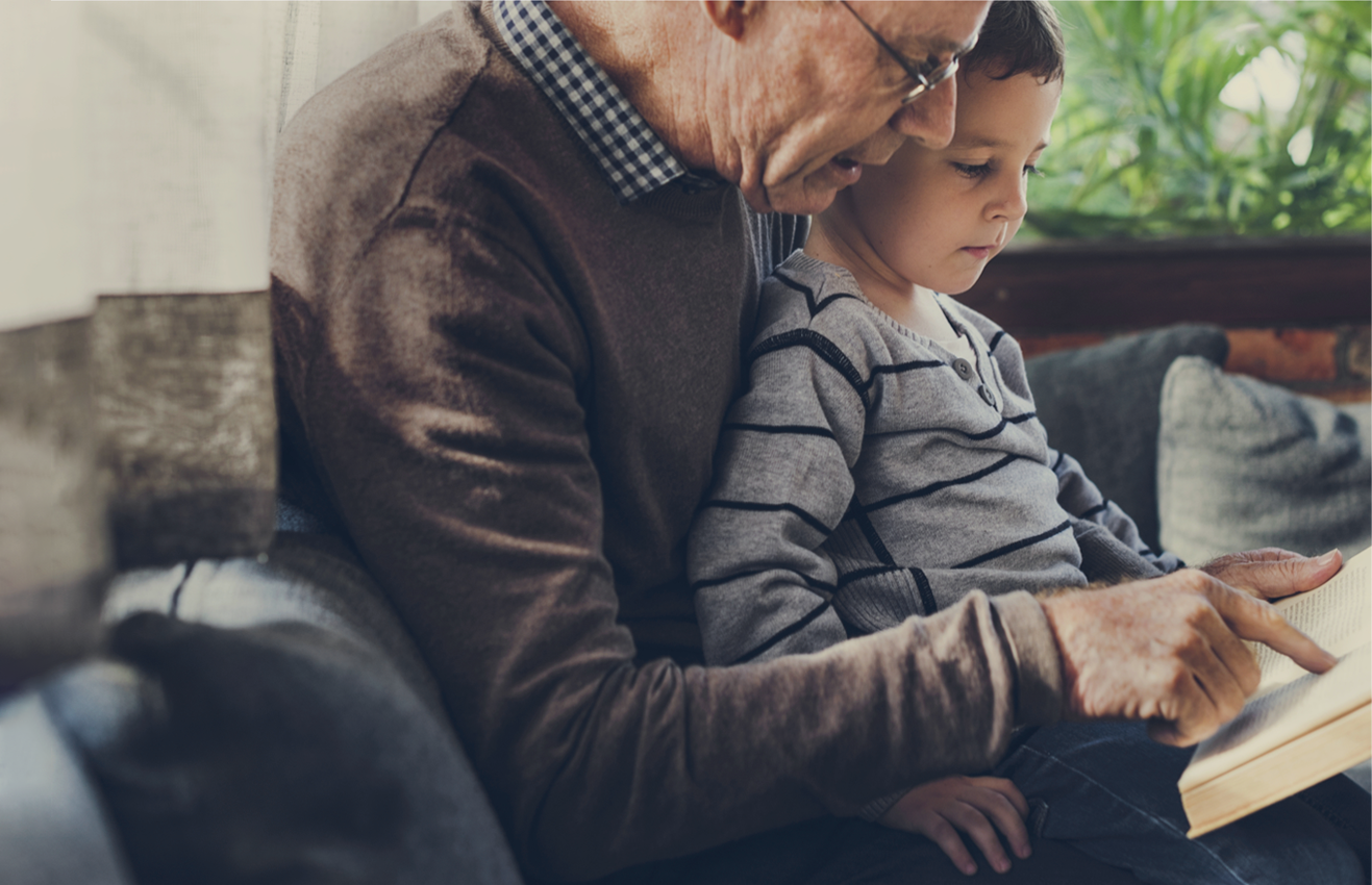 Grandfather reading to grandson