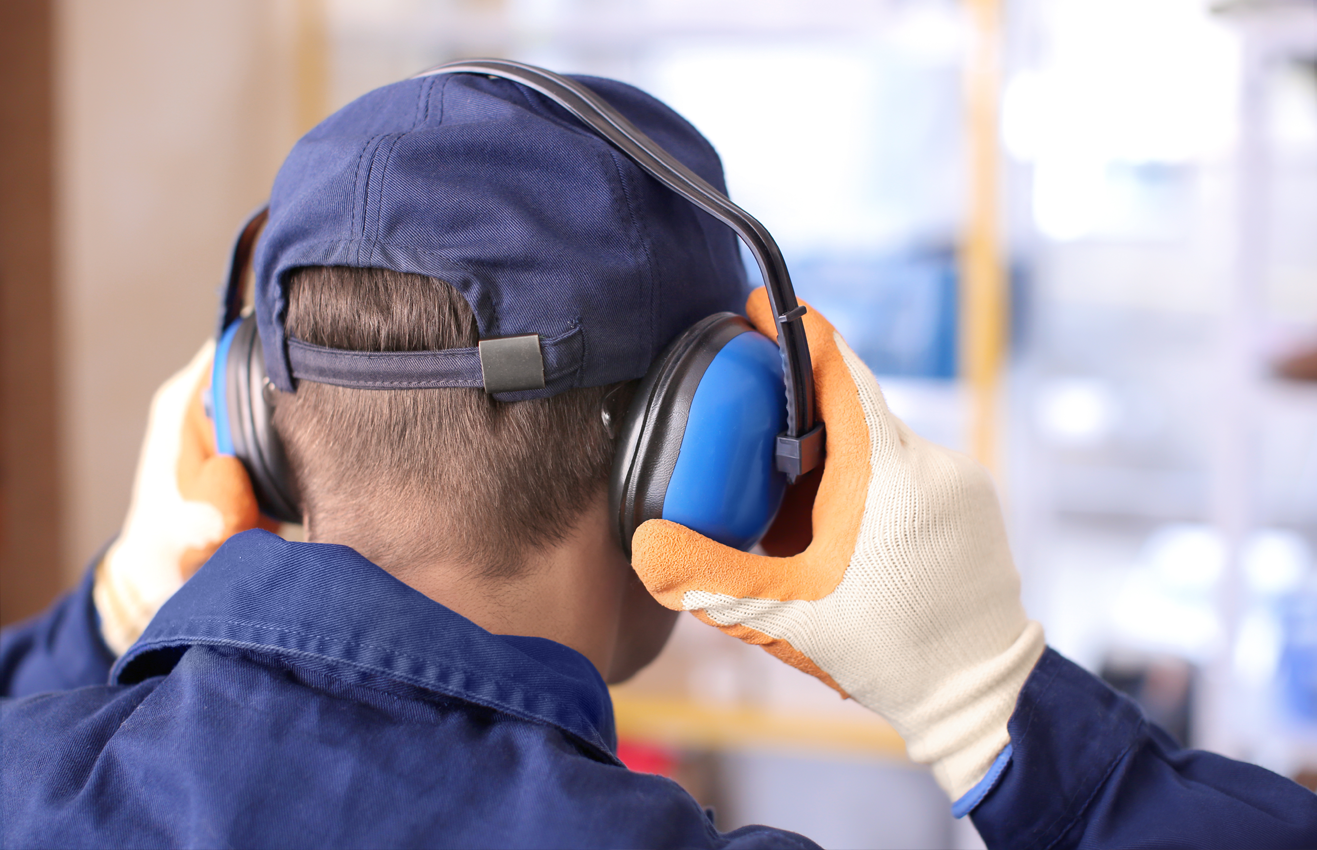 A man wearing ear muffs at work to protect his hearing